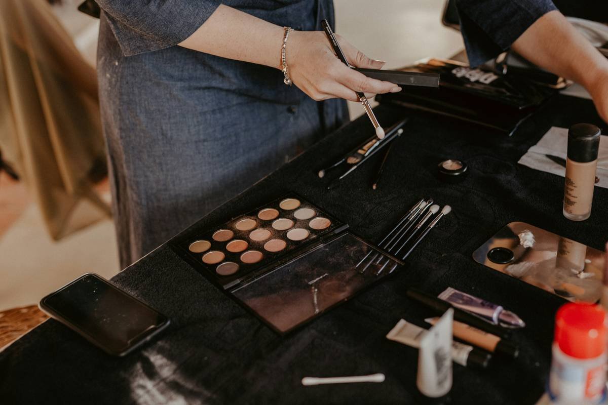 a woman is putting makeup on a table