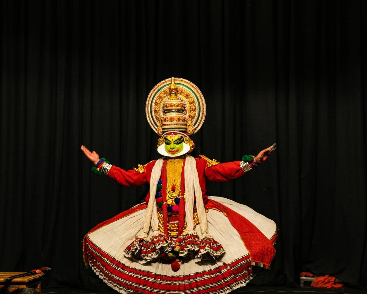 Kathakali dancer in elaborate costume and makeup performs.
