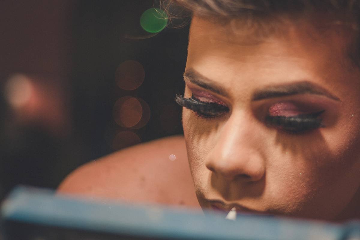 Close-up of a drag artist applying alcohol-activated paint over a foam latex brow ridge, blending edges with a stipple sponge