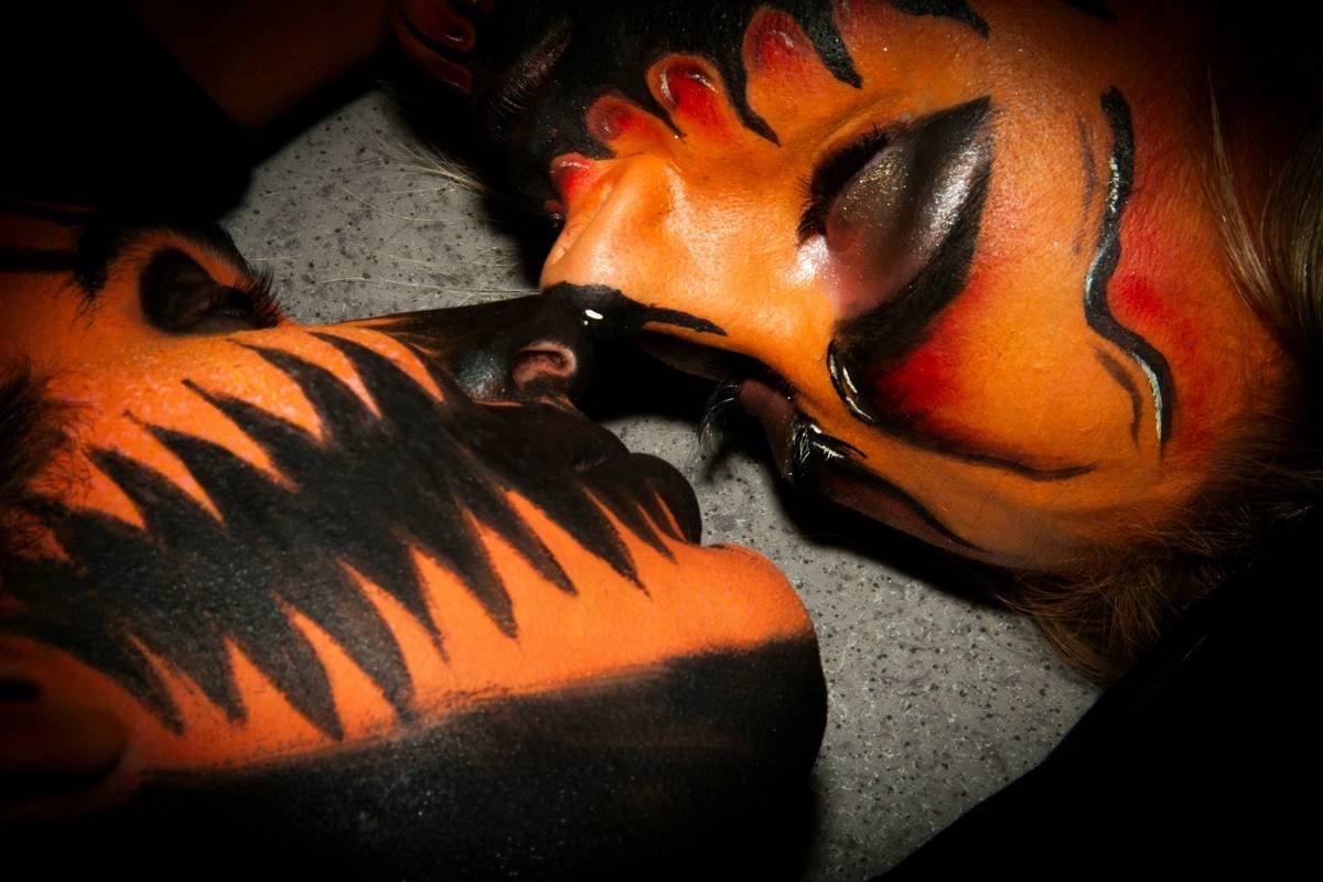 Close-up of theatrical makeup for sci-fi alien prosthetic applied on actor's face under stage lighting